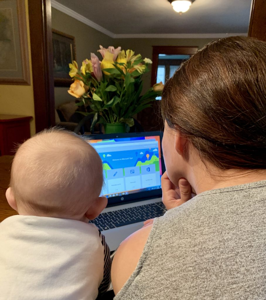 Amanda and her baby looking at a laptop screen